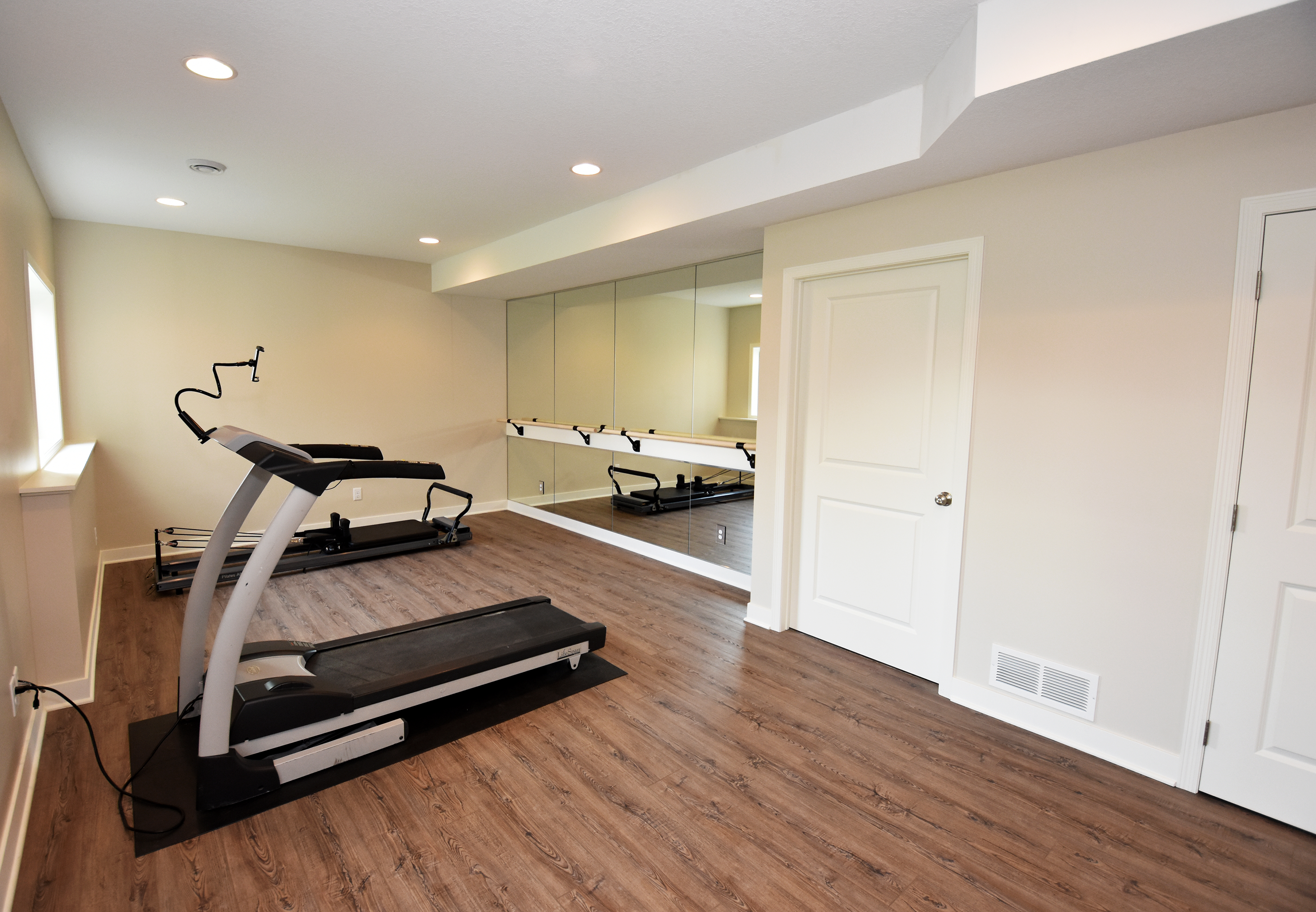 Basement home gym - exercise equipment - large mirror