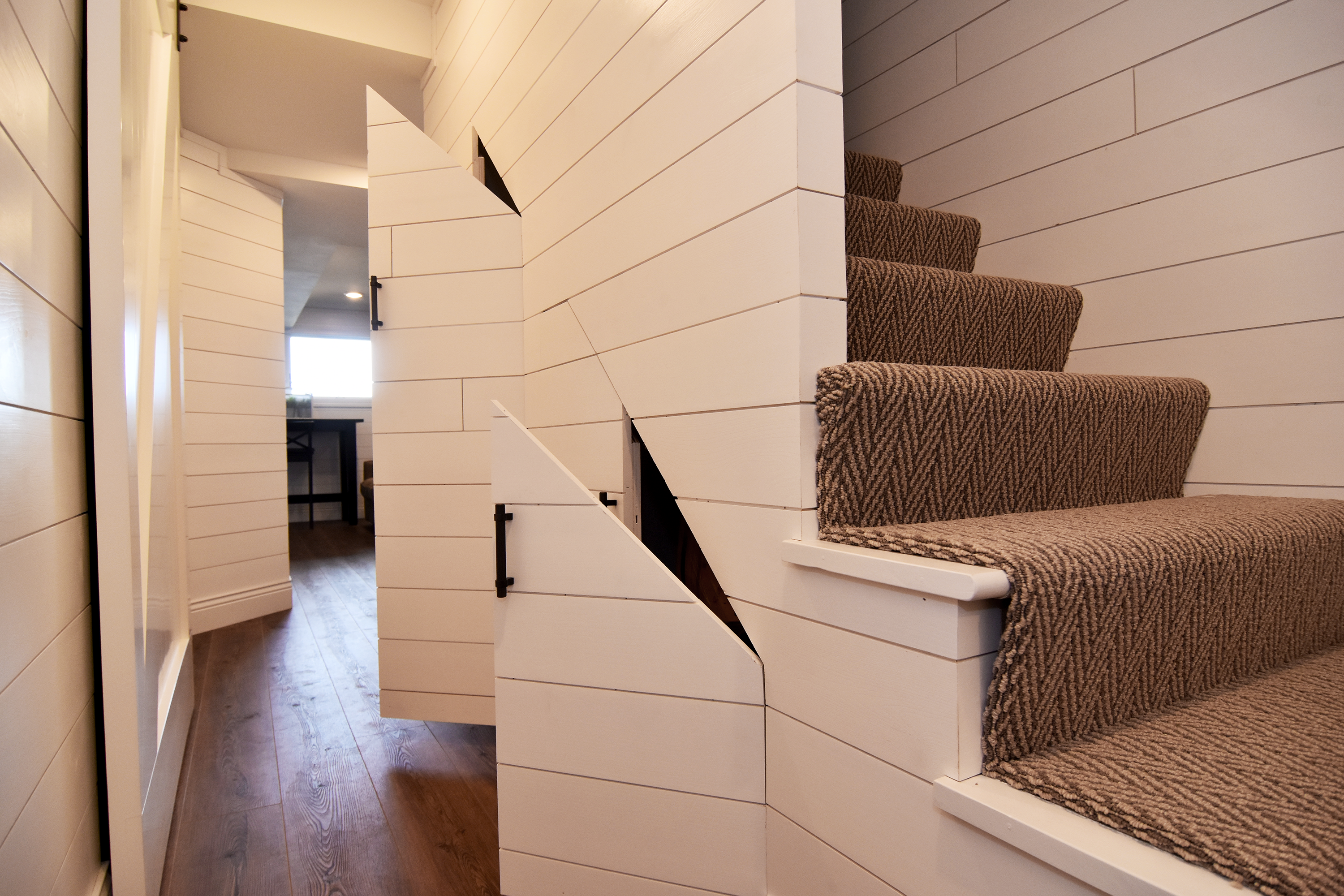 Cozy Basement - Staircase - White Wood with doors for storage under staircase