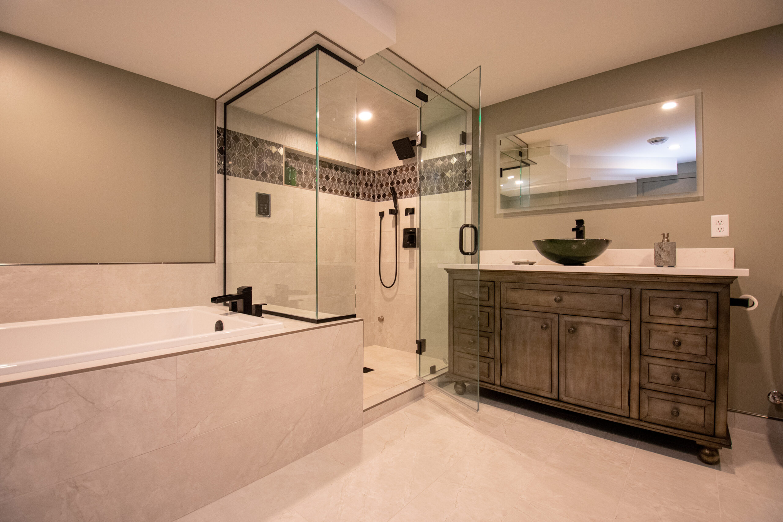 Modern bathroom remodel with tub, glassed shower, vanity, and lit mirror