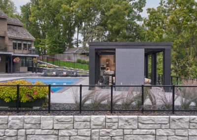 View of contemporary poolhouse from retaining wall